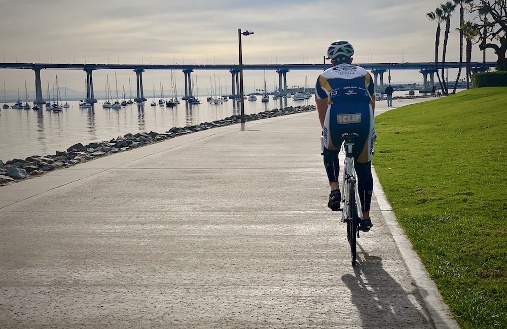 person on bicycle looking at view of the bay